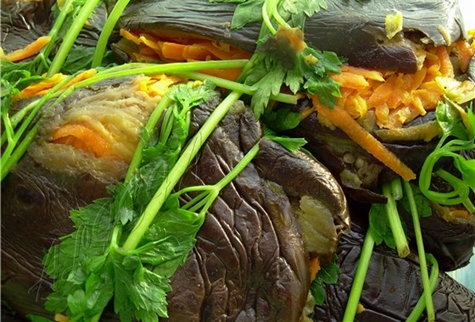 marinuoti baklažanai su morkomis, žolelėmis ir česnakais ant stalo