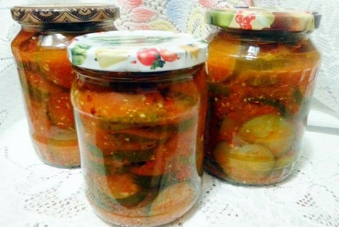 cucumbers in adjika in jars on the table