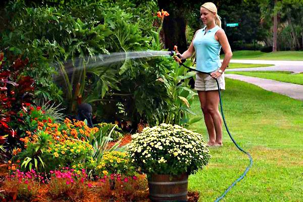 dievča zalievanie záhrady hadicami